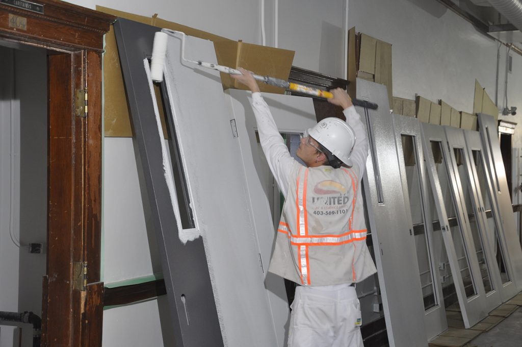 With the installation of freshly painted modern doors alongside historic ones, the fresh paint has also enlivened the corridors with the intent for these spaces to be galleries and backdrops for art.